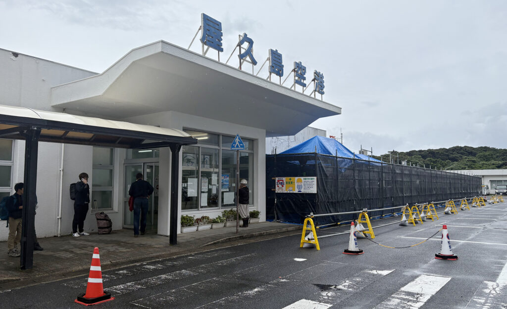 屋久島空港ターミナルの出入口付近に仮設の停留所を移せば、乗客は軒下でバスを待つことができる=2025年11月5日、屋久島ポスト撮影